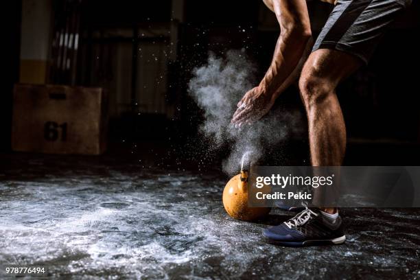 young man putting on sports chalk for lifting barbell - sports chalk stock pictures, royalty-free photos & images