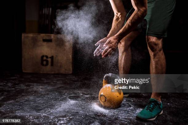 young man putting on sports chalk for lifting barbell - chalk hands stock pictures, royalty-free photos & images