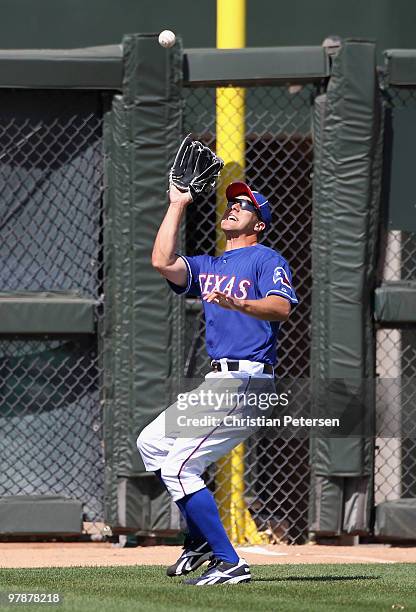 Outfielder David Murphy of the Texas Rangers catches a fly ball out during the MLB spring training game against the Cleveland Indians at Surprise...