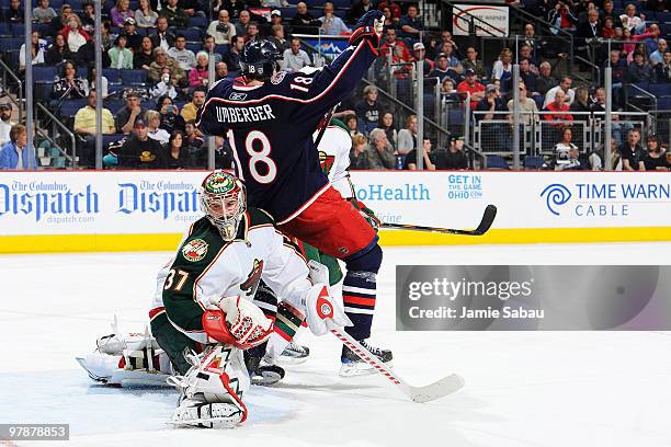 Umberger of the Columbus Blue Jackets looses his footing as goaltender Josh Harding of the Minnesota Wild is unable to stop a shot from Kris Russell...