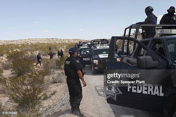 Mexican police and stand at a site which is believed to hold the remains of numerous bodies in what is thought to be a large grave in the desert of...