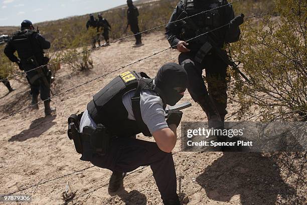 Mexican police work at a site in the desert believed to hold the remains of numerous victims of recent drug violence on March 19, 2010 in the county...