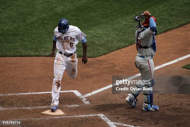 Lorenzo Cain of the Milwaukee Brewers scores a run past Jorge Alfaro of the Philadelphia Phillies in the fifth inning at Miller Park on June 17, 2018...