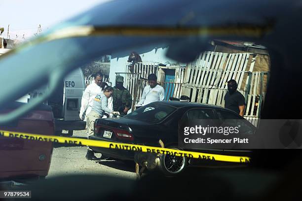 Police and military examine a body at a murder scene on March 19, 2010 in Juarez, Mexico. The border city of Juarez has been racked by violent...