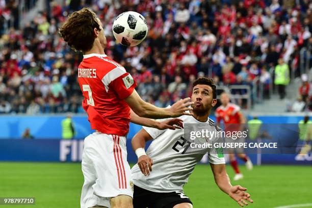 Egypt's forward Mahmoud 'Trezeguet' Hassan fights for the ball with Russia's defender Mario Fernandes during the Russia 2018 World Cup Group A...