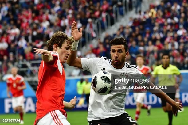 Egypt's forward Mahmoud 'Trezeguet' Hassan fights for the ball with Russia's defender Mario Fernandes during the Russia 2018 World Cup Group A...