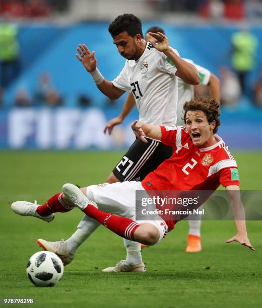 Mario Fernandes of Russia is tackled by Trezeguet of Egypt during the 2018 FIFA World Cup Russia group A match between Russia and Egypt at Saint...