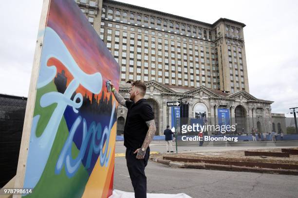 An artist paints a mural ahead of a Ford Motor Co. Event at the Michigan Central Station in the Corktown neighborhood of Detroit, Michigan, U.S., on...