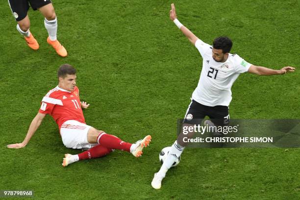 Egypt's forward Mahmoud 'Trezeguet' Hassan vies for the ball with Russia's midfielder Roman Zobnin during the Russia 2018 World Cup Group A football...