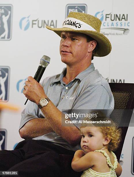 Runner-up Briny Baird talks to the media, as his 19-month-old daughter Madison listens, after playing the Magnolia course at Walt Disney World Resort...