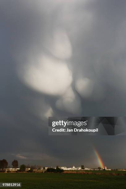 mammatus clouds with rainbow, prague, czech republic - mammatus cloud stock pictures, royalty-free photos & images