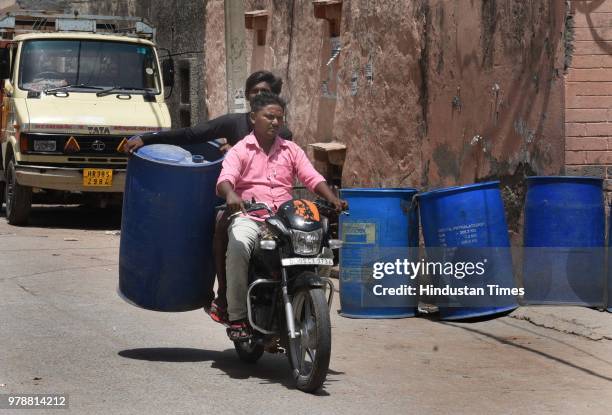 Locals carry water container to get water from nearby areas due to water crisis at Harijan Basti, Aya Nagar, on June 19, 2018 in New Delhi, India.