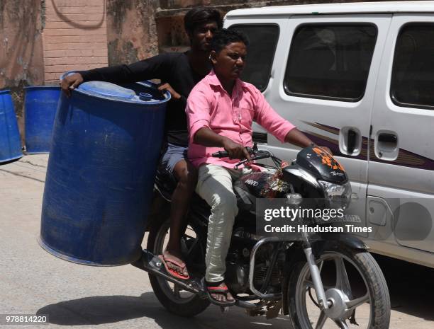 Locals carry water container to get water from nearby areas due to water crisis at Harijan Basti, Aya Nagar, on June 19, 2018 in New Delhi, India.