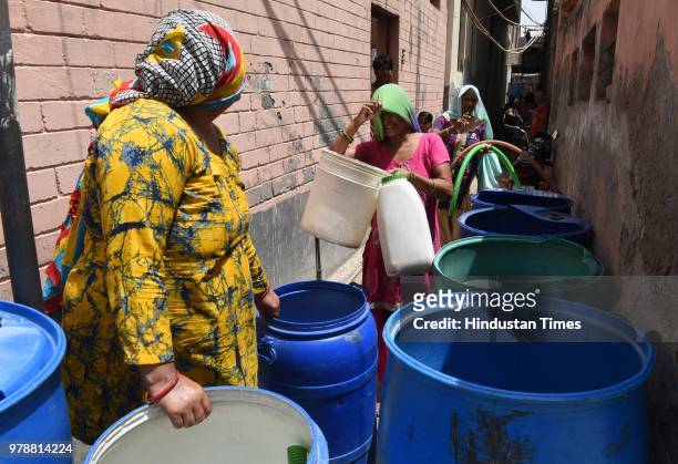 Women wait in queue to fill water from a water tanker due to heavy water crisis at Harijan Basti, Aya Nagar, on June 19, 2018 in New Delhi, India.