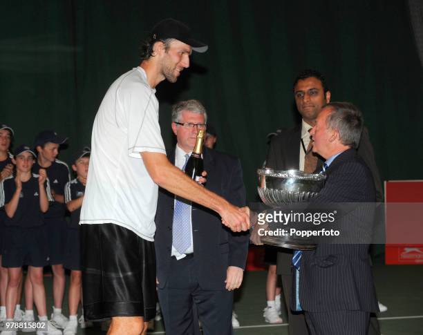 Ivo Karlovic of Croatia receives the trophy after defeating Fernando Verdasco of Spain in the Singles Final of the Nottingham Open tennis tournament...