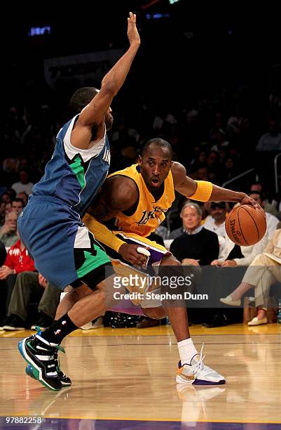Kobe Bryant of the Los Angeles Lakers drives around Wayne Elllington of the Minnesota Timberwolves on March 19, 2010 at Staples Center in Los...