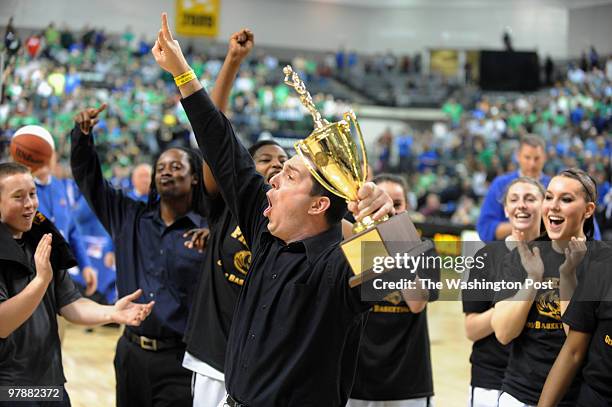 Freedom's Head Coach holding the State Championship Trophy and signals to the crowd it's the second year in a row for his team on March 13, 2010.