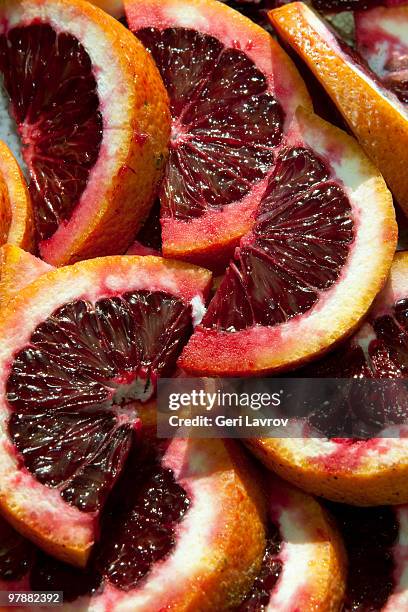 sliced blood oranges - bloedsinaasappel stockfoto's en -beelden
