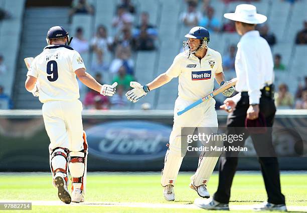 Cameron White of Vicotira congratulates David Hussey after Hussey scored 150 runs during day four of the Sheffield Shield Final between the Victorian...