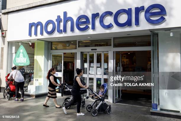 Shoppers walk past a Mothercare shop on Wood Green High Street in north London on June 19, 2018. - Major UK retailers are increasingly facing tough...