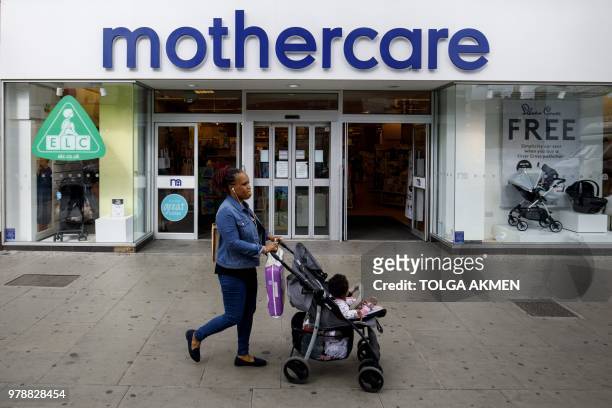 Shoppers walk past a Mothercare shop on Wood Green High Street in north London on June 19, 2018. - Major UK retailers are increasingly facing tough...