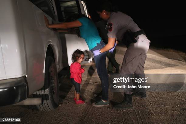 Two-year-old Honduran asylum seeker cries as her mother is searched and detained near the U.S.-Mexico border on June 12, 2018 in McAllen, Texas. The...