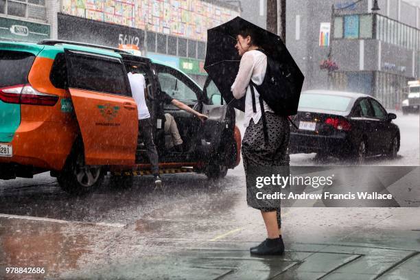 Downpouring of rain soaks a pedestrian on Wellesley St. E.. The GTA is experiencing weather very humid conditions for the start of this week.