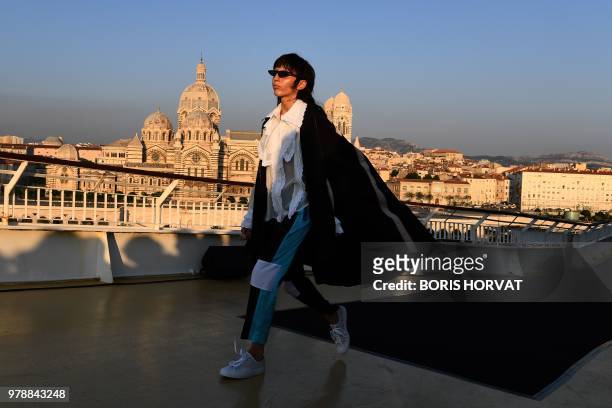 Model presents a creation for Koche fashion house during "Open My Med" fashion show on June 19, 2018 in Marseille. - In the background, the Cathedral...