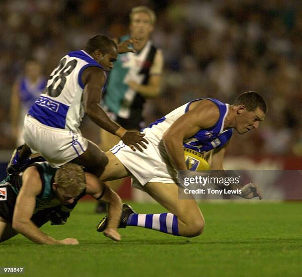 Adam Lange for the Kangaroos tumbles over Steven paxman for Port Adelaide as he marks in the Ansett Cup semi-final match between Port Power and the...