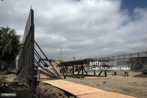 Workers in Mesa de Otay, San Diego, California, in the US, replace a section of the Mexico-US border fence as seen from Tijuana, in Mexico, on June...