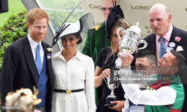 Prince Harry, Duke of Sussex and Meghan, Duchess of Sussex, making her Royal Ascot debut, present the trophy for the St James's Palace Stakes to...