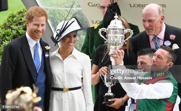 Prince Harry, Duke of Sussex and Meghan, Duchess of Sussex, making her Royal Ascot debut, present the trophy for the St James's Palace Stakes to...