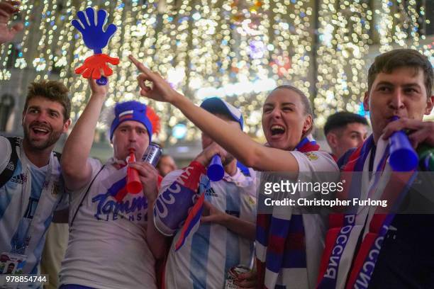 Russian football fans celebrate their national team's 3-1 win over Egypt on Nikolskaya Street, near Red Square, on June 19, 2018 in Moscow, Russia.