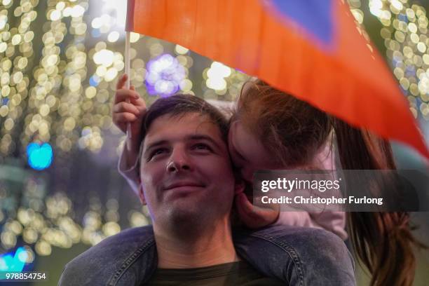 Russian football fans celebrate their national team's 3-1 win over Egypt on Nikolskaya Street, near Red Square, on June 19, 2018 in Moscow, Russia.