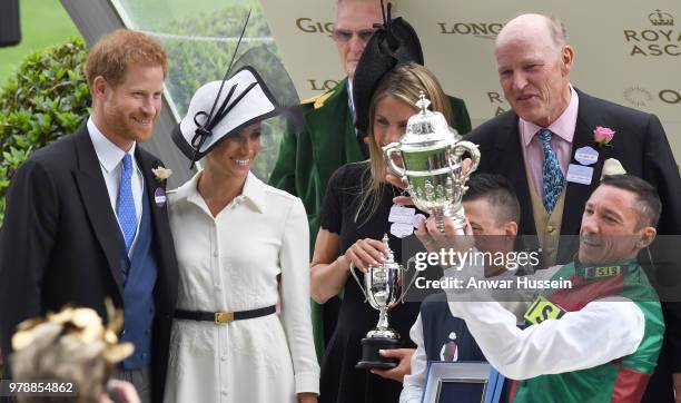 Prince Harry, Duke of Sussex and Meghan, Duchess of Sussex, making her Royal Ascot debut, present the trophy for the St James's Palace Stakes to...