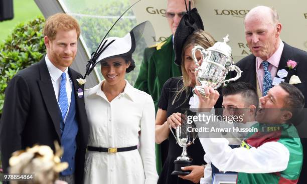 Prince Harry, Duke of Sussex and Meghan, Duchess of Sussex, making her Royal Ascot debut, present the trophy for the St James's Palace Stakes to...