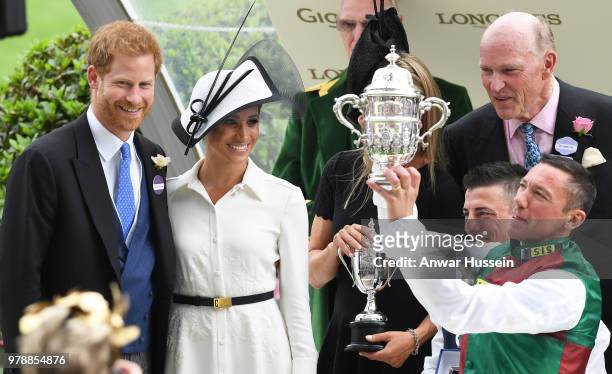 Prince Harry, Duke of Sussex and Meghan, Duchess of Sussex, making her Royal Ascot debut, present the trophy for the St James's Palace Stakes to...