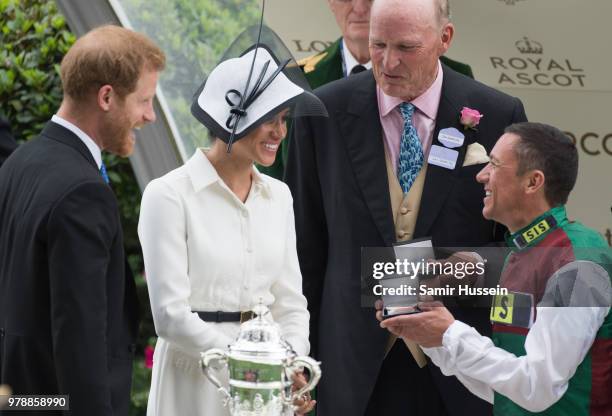 Meghan, Duchess of Sussex and Prince Harry, Duke of Sussex present the trophy for the St James's Palace Stakes to winning jockey Frankie Dettori as...