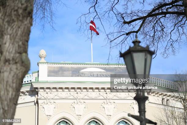 Febuary 2018, Latvia, Riga: A Latvian flag blows in the wind on the main building of the Latvian Central Bank in Riga. Photo: Alexander Welscher/dpa