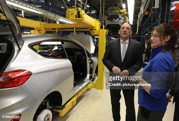 February 2018, Germany, Cologne: Detlef Scheele, CEO of the Federal Labour Office , speaks with the trainee Sophie Scharr at the production plant of...