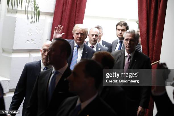 President Donald Trump, center left, waves while walking with House Majority Leader Kevin McCarthy, a Republican from California, as Democratic...