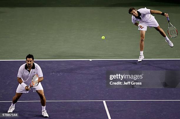 Daniel Nestor of Canada and Nenad Zimonjic of Serbia serve to the team of John Isner and Sam Querrey of USA during the men's doubles semifinal of the...