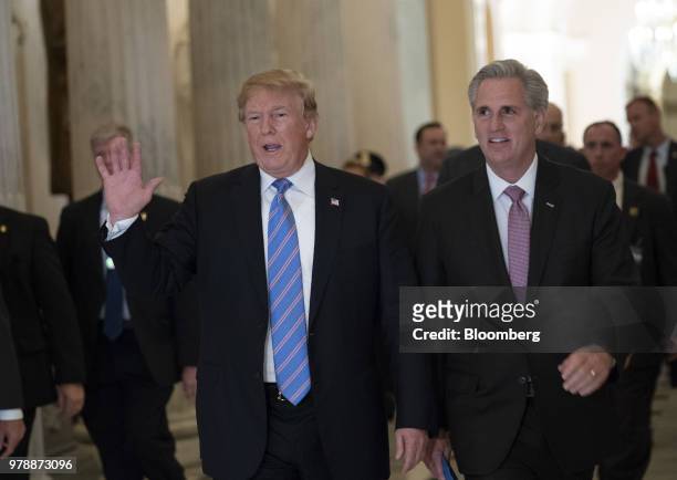 President Donald Trump, left, waves while walking with House Majority Leader Kevin McCarthy, a Republican from California, right, after a House...