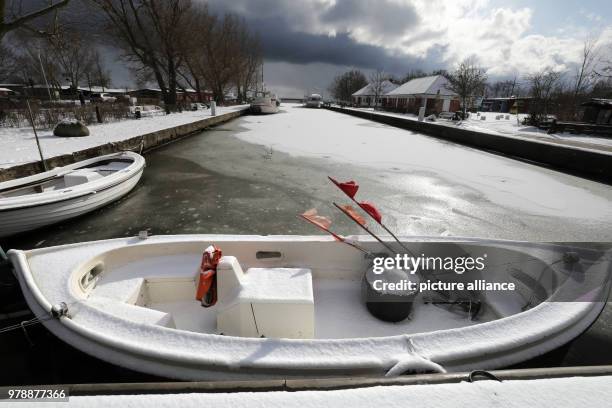 Dpatop - A snowed in fishing boat moors in a ice and snow covered inner bay harbour, in Wustrow, Germany, 25 February 2018. Photo: Bernd...