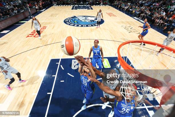 Sylvia Fowles of the Minnesota Lynx reaches fro the ball against Allisha Gray of the Dallas Wings and Glory Johnson of the Dallas Wings on June 19,...