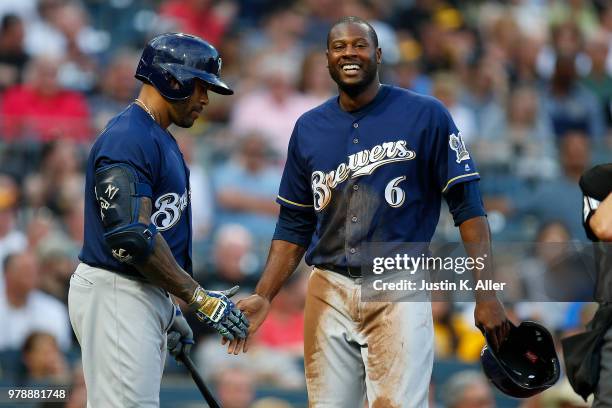 Lorenzo Cain of the Milwaukee Brewers celebrates with Eric Thames of the Milwaukee Brewers after scoring on an RBI double in the third inning against...
