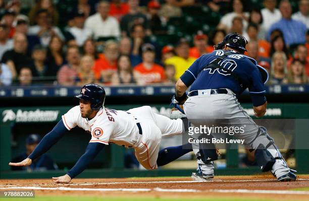 George Springer of the Houston Astros slides around Wilson Ramos of the Tampa Bay Rays in the first inning but missed home plate and was called out...