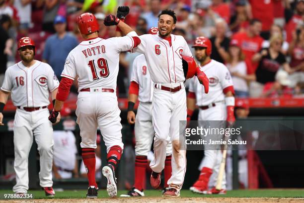 Billy Hamilton of the Cincinnati Reds celebrates at home plate with Joey Votto of the Cincinnati Reds after Votto's third inning grand slam against...