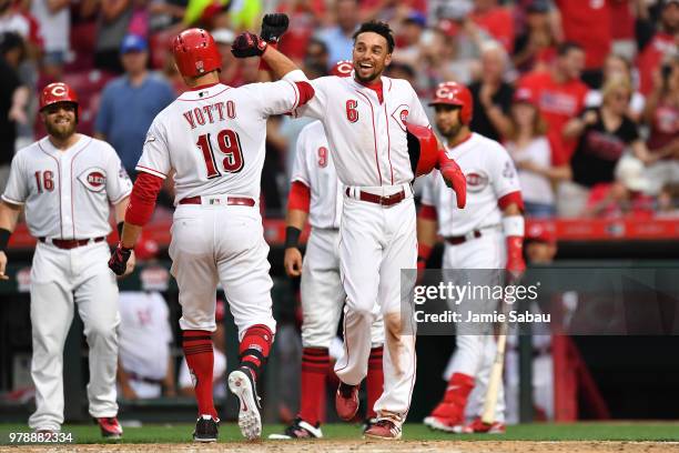 Billy Hamilton of the Cincinnati Reds celebrates at home plate with Joey Votto of the Cincinnati Reds after Votto's third inning grand slam against...