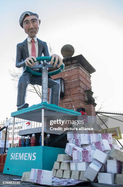 February 2018, Germany, Berlin: A huge figure of Siemens CEO Joe Kaeser seen during a rally of IG Metall outside the Siemes Dynamo plant. Photo: Paul...